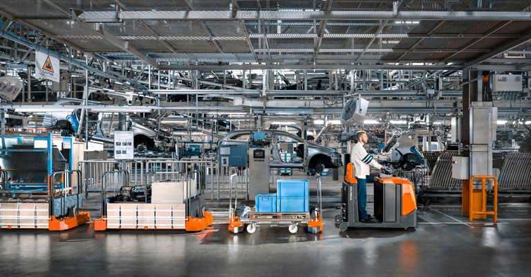 Driver on BT Movit tow train in car factory